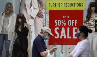 Shoppers pass a sale sign in a shop window on Oxford Street in London, Thursday, Aug. 13, 2020. The British economy is on course to record the deepest coronavirus-related slump among the world&#39;s seven leading industrial economies after official figures showed it shrinking by a 20.4% in the second quarter of 2020 alone said The Office for National Statistics. (AP Photo/Kirsty Wigglesworth)