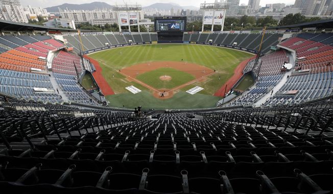 FILE - In this Aug. 16, 2020, file photo, empty stadium without fans as a precautionary measure is seen during the KBO league baseball game between KT Wiz and Doosan Bears in Seoul. South Korea may have been way ahead of the international curve in getting sport back to some semblance of normality but instead of near-full stadiums watching the end of baseball and soccer seasons later this year, a recent spike in coronavirus cases means officials will settle for just finishing the season at all.(AP Photo/Lee Jin-man, File)