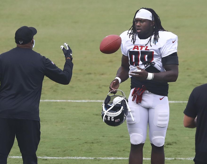 Atlanta Falcons defensive end Takk McKinley takes the field and a football during an NFL training camp football practice Saturday, Aug. 22, 2020, in Flowery Branch, Ga. (Curtis Compton/Atlanta Journal-Constitution via AP, Pool)