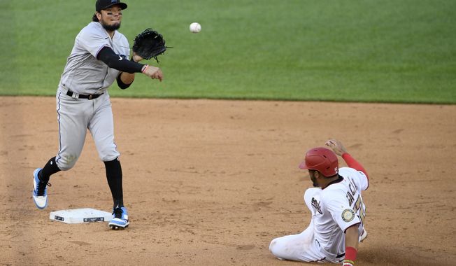 Washington Nationals&#x27; Luis Garcia, right, is out at second as Miami Marlins shortstop Miguel Rojas, left, throws to first to get out Carter Kieboom and compete a double-play during the sixth inning of the first baseball game of a doubleheader, Saturday, Aug. 22, 2020, in Washington. (AP Photo/Nick Wass)