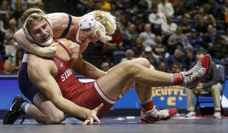 FILE - In this Jan. 2, 2019, file photo, Penn State&#39;s Bo Nickal, rear left, wrestles with Stanford&#39;s Nathan Traxler in the 197-pound championship bout of the Southern Scuffle wrestling tournament in Chattanooga, Tenn. Stanford announced Wednesday, July 8, 2020,  that it is dropping 11 sports amid financial difficulties caused by the coronavirus pandemic. The school will discontinue men’s and women’s fencing, field hockey, lightweight rowing, men’s rowing, co-ed and women’s sailing, squash, synchronized swimming, men’s volleyball and wrestling after the 2020-21 academic year. Stanford also is eliminating 20 support staff positions.(C.B. Schmelter/Chattanooga Times Free Press via AP, File)