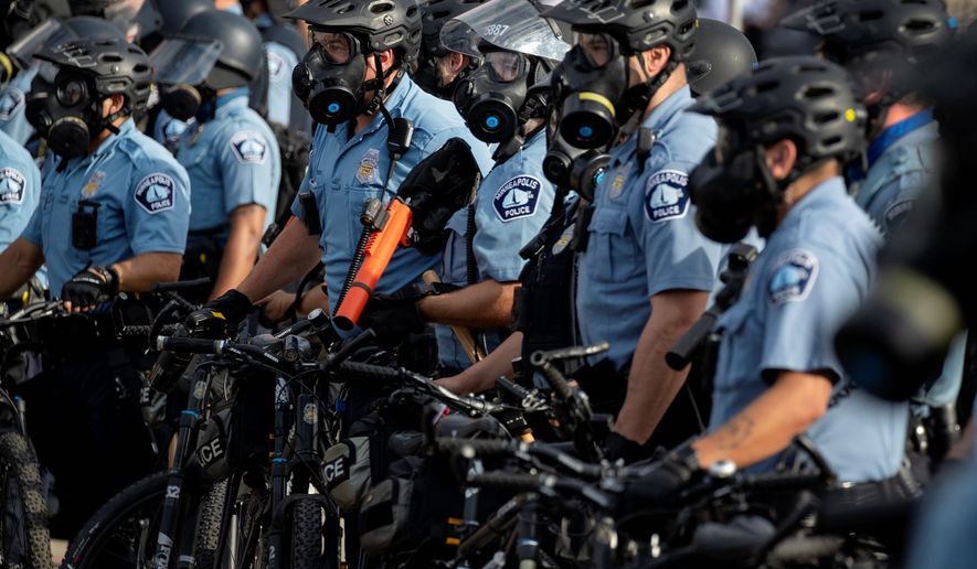 In this May 27, 2020, file photo, police gather en masse as protests continue at the Minneapolis 3rd Police Precinct in Minneapolis. More than 150 Minneapolis police officers have started the process of filing for disability claims since the death of George Floyd and the ensuing unrest in the city, with the majority citing post-traumatic stress disorder as the reason for their planned departure, according to an attorney representing the officers. (Carlos Gonzalez/Star Tribune via AP, File)