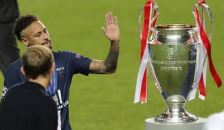 PSG&#39;s head coach Thomas Tuchel, left, watches as PSG&#39;s Neymar touches the trophy for winners of the Champions League final soccer match between Paris Saint-Germain and Bayern Munich at the Luz stadium in Lisbon, Portugal, Sunday, Aug. 23, 2020. (Miguel A. Lopes/Pool via AP)