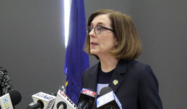 In this March 16, 2020, file photo, Oregon Gov. Kate Brown speaks at a news conference in Portland, Ore., to announce a four-week ban on eat-in dining at bars and restaurants, due to COVID-19, throughout the state. As she was putting the finishing touches on a reopening plan in May, Oregon Gov. Kate Brown received a letter from a coalition of business groups pressing for more say in the process. (AP Photo/Gillian Flaccus, File)