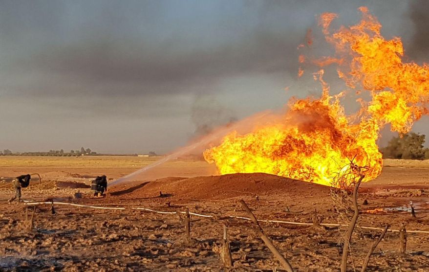 In this photo released by the Syrian official news agency SANA, Syrian firefighters extinguish the flames of a gas pipeline that hit by an explosion, between the northeastern Damascus suburbs of Adra and Dumair, in Syria Monday, Aug. 24, 2020. An explosion early on Monday struck a gas pipeline in a Damascus suburb, cutting electricity throughout Syria, state media reported, citing the country's electricity and oil ministers. (SANA via AP)