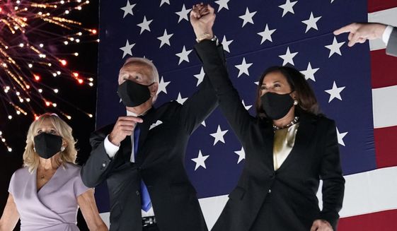 Democratic presidential candidate former Vice President Joe Biden raises his arm with his running mate Sen. Kamala Harris, D-Calif., during the fourth day of the Democratic National Convention, Thursday, Aug. 20, 2020, at the Chase Center in Wilmington, Del. Jill Biden is at left. (AP Photo/Andrew Harnik)