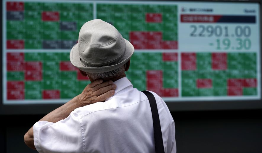 A man looks at an electronic stock board showing Japan's Nikkei 225 index at a securities firm in Tokyo Monday, Aug. 24, 2020. Asian stock markets rose Monday after Wall Street hit a new high despite lingering unease about a possible second wave of coronavirus infections. (AP Photo/Eugene Hoshiko)