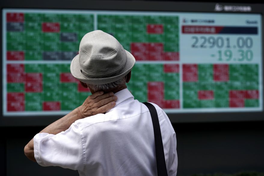 A man looks at an electronic stock board showing Japan's Nikkei 225 index at a securities firm in Tokyo Monday, Aug. 24, 2020. Asian stock markets rose Monday after Wall Street hit a new high despite lingering unease about a possible second wave of coronavirus infections. (AP Photo/Eugene Hoshiko)