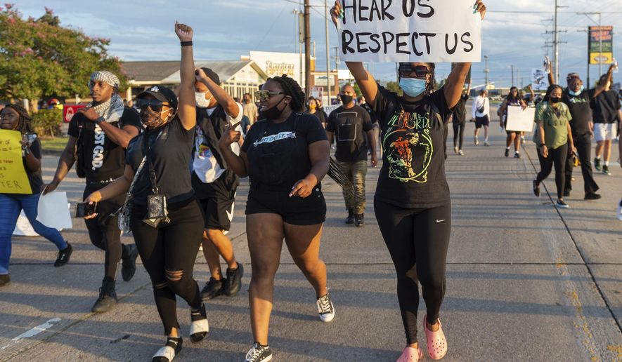 Protesters march down Amb Caffery and Johnston St. Sunday, Aug. 23, 2020, in Lafayette, La. (Scott Clause/The Daily Advertiser via AP)