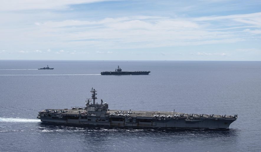 In this July 6, 2020, file photo provided by U.S. Navy, the USS Ronald Reagan (CVN 76, front) and USS Nimitz (CVN 68, rear) Carrier Strike Groups sail together in formation, in the South China Sea. (Mass Communication Specialist 3rd Class Jason Tarleton/U.S. Navy via AP, File)  **FILE**