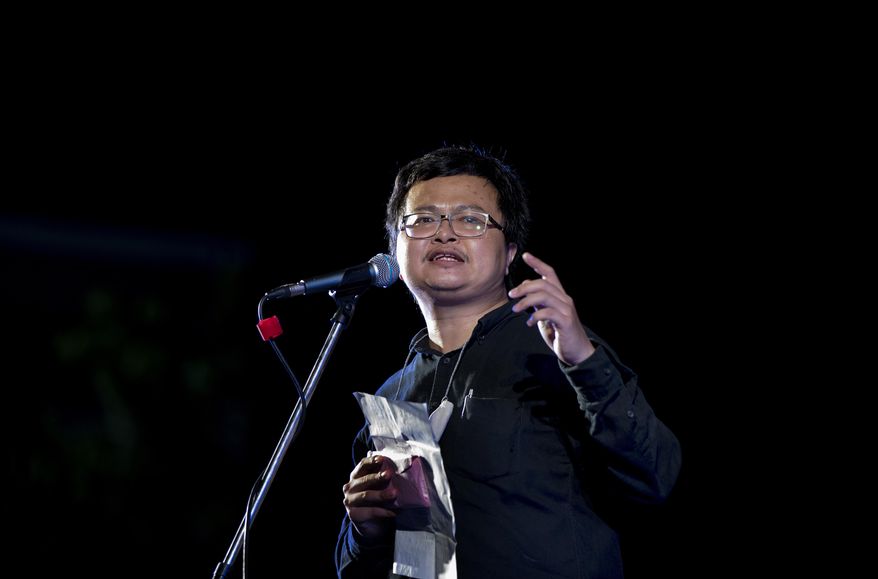 In this Sunday, Aug. 16, 2020, photo, pro-democracy activist and human rights lawyer Arnon Nampha delivers a speech during a protest rally at the Democracy Monument in Bangkok, Thailand. Thai police issued summons to five activists including Arnon who spoke at an anti-government rally in front of the army headquarters last July 20, for the violation of the emergency decree which prohibits public gatherings during the coronavirus outbreak. (AP Photo/Gemunu Amarasinghe)