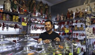 David Herrera, Botanica La Caridad proprietor and santero, poses for a photo in his store on Wednesday, July 29, 2020. Since the start of the pandemic, some people have searched for services and products from businesses like Herrera&#39;s to ease their anxiety or stress. Sage, candles and cleansing ceremonies have been in demand according to Herrera. (Kin Man Hui/The San Antonio Express-News via AP)
