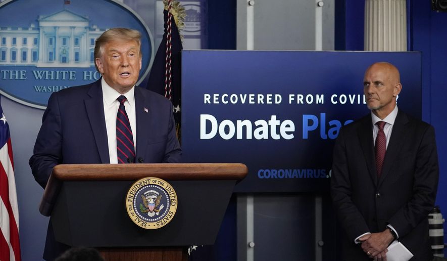 President Donald Trump speaks as Stephen Hahn, commissioner of the U.S. Food and Drug Administration, listens during a media briefing in the James Brady Briefing Room of the White House, Sunday, Aug. 23, 2020, in Washington.(AP Photo/Alex Brandon)