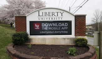 FILE - In this March 24, 2020 file photo, a sign marks the entrance to Liberty University, Tuesday March 24 , 2020, in Lynchburg, Va.  Jerry Falwell Jr. said Tuesday, Aug. 25, that he has resigned as head of evangelical Liberty University because of ongoing controversies about his wife’s sexual involvement with a younger business partner and in the wake of a social media photo that caused an uproar.  (AP Photo/Steve Helber)