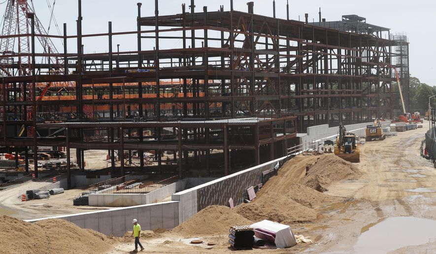 FILE - In this Wednesday, May 27, 2020, file photo, work resumes, amid the coronavirus pandemic, on the New York Islanders' new hockey arena, located adjacent to Belmont Park racetrack, in Elmont, N.Y. The New York Islanders have reached a 20-year naming rights deal for their new arena with wealth management service UBS. The facility on the grounds of the Belmont Park racetrack will be called UBS Arena at Belmont Park. It's projected to open in time for the 2021-22 NHL season. (AP Photo/Kathy Willens, File)