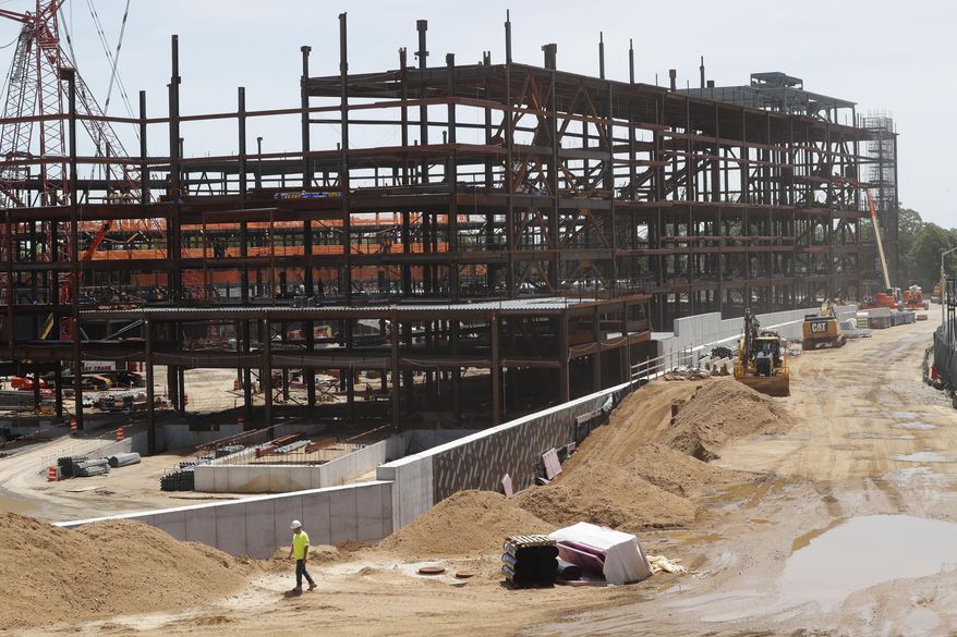 FILE - In this Wednesday, May 27, 2020, file photo, work resumes, amid the coronavirus pandemic, on the New York Islanders' new hockey arena, located adjacent to Belmont Park racetrack, in Elmont, N.Y. The New York Islanders have reached a 20-year naming rights deal for their new arena with wealth management service UBS. The facility on the grounds of the Belmont Park racetrack will be called UBS Arena at Belmont Park. It's projected to open in time for the 2021-22 NHL season. (AP Photo/Kathy Willens, File)
