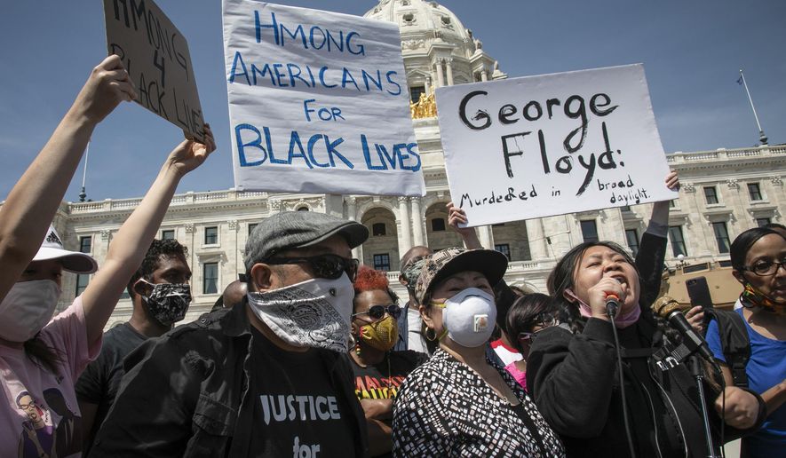 Ze Thao, second from right, addresses a Black Lives Matter rally for George Floyd with fellow Hmong activist Youa Vang Lee, center, at the Minnesota State Capitol, Sunday, May 31, 2020, in St. Paul, Minn. The climate of racial reckoning that has emerged in the United States since Floyd’s death has reinvigorated Native Americans, Asian Americans, Latinos and other people of color to fight back against the racism and discrimination they also have experienced for decades. (AP Photo/Bebeto Matthews)