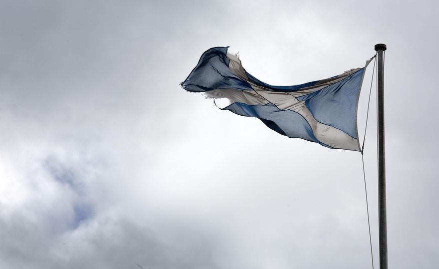 A torn Scottish Saltire flag hangs over the Royal Mile in Edinburgh, Scotland, Friday, Aug, 21, 2020. The handling of the coronavirus pandemic by Scottish leader Nicola Sturgeon has drawn praise, in contrast to the sometimes-chaotic approach of U.K. Prime Minister Boris Johnson. That has catapulted the idea of Scottish independence from the U.K. back up the political agenda. (AP Photo/David Cheskin)