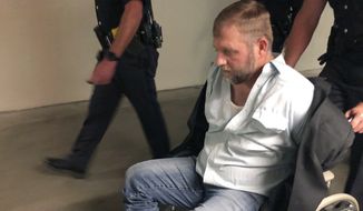 Anti-government activist Ammon Bundy is wheeled from the Idaho Statehouse in Boise, Idaho, on Wednesday, Aug. 26, 2020, following his second arrest for trespassing in two days. Bundy was arrested Tuesday in a committee room and charged with trespassing. (AP Photo/Keith Ridler)
