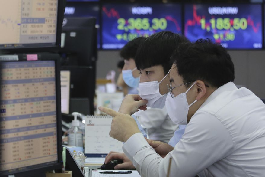 Currency traders watch monitors at the foreign exchange dealing room of the KEB Hana Bank headquarters in Seoul, South Korea, Thursday, Aug. 27, 2020. Asian stock markets retreated Thursday as investors looked ahead to a speech by the U.S. Federal Reserve chairman for signs of more support to an economic recovery. (AP Photo/Ahn Young-joon)