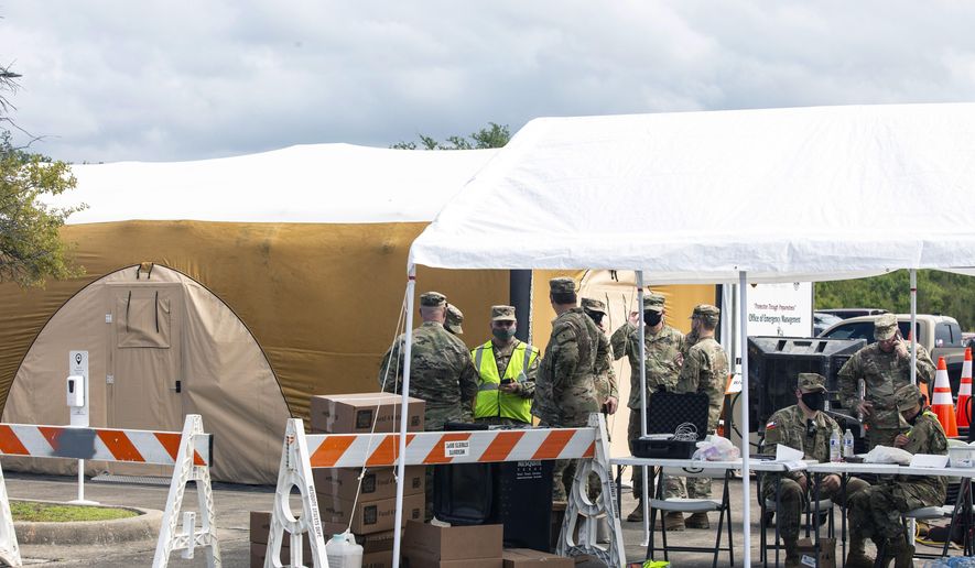 Military personnel wait to receive hurricane evacuees at the Mesquite Reception Center set up for hurricane evacuees in Mesquite, Texas, Wednesday, Aug. 26, 2020. Thousands of Gulf Coast residents fled inland from an approaching storm deemed “unsurvivable” by forecasters, heeding warnings from leaders in two states, but leaving some without help as available space in hotels and shelters filled quickly. (Lynda M. González/The Dallas Morning News via AP)
