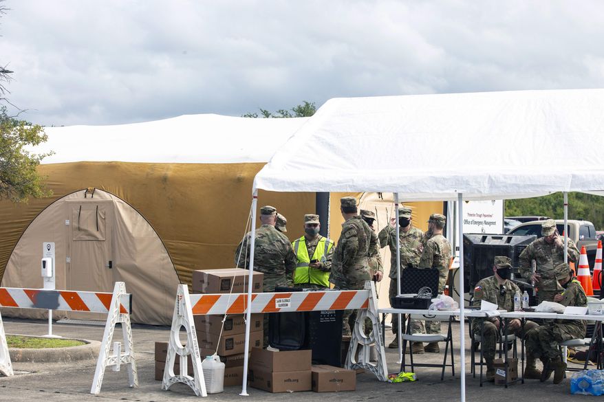 Military personnel wait to receive hurricane evacuees at the Mesquite Reception Center set up for hurricane evacuees in Mesquite, Texas, Wednesday, Aug. 26, 2020. Thousands of Gulf Coast residents fled inland from an approaching storm deemed “unsurvivable” by forecasters, heeding warnings from leaders in two states, but leaving some without help as available space in hotels and shelters filled quickly. (Lynda M. González/The Dallas Morning News via AP)