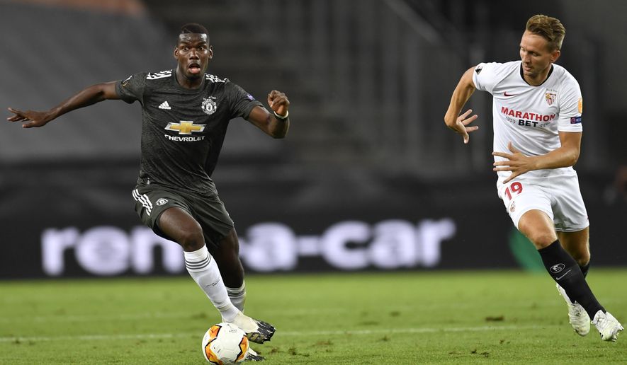 Manchester&#39;s Paul Pogba, left, and Sevilla&#39;s Luuk de Jong challenge for the ball during the UEFA Europa League semifinal match between FC Sevilla and Manchester United in Cologne, Germany, Sunday, Aug. 16, 2020. (Marius Becker/dpa via AP)