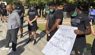 Members of the Baylor football team including Dave Aranda, bow their heads during a prayer after marching around campus, Thursday, Aug. 27, 2020, in Waco, Texas, protesting the shooting of Jacob Blake in Wisconsin. (Rod Aydelotte/Waco Tribune-Herald via AP)
