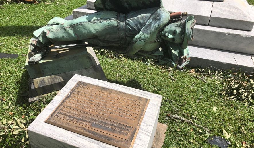 A statue of a Confederate soldier in front of a courthouse in Lake Charles, La., lies on the ground Thursday Aug. 27, 2020 after being toppled when Hurricane Laura ripped through the area. Earlier this month parish officials voted to keep the statue, called the South’s Defenders Monument, in its place. (AP Photo/Melinda Deslatte)