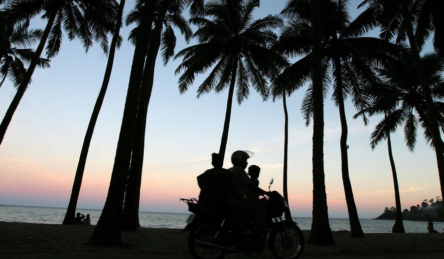 A motorist drives along the sea shore with his family in Port Blair, in India's Andaman and Nicobar Islands archipelago, Saturday, Sept. 8, 2007. Four members of a small tribe in the remote Andaman and Nicobar Islands have tested positive for the coronavirus. An Indian health official says the four are among the 37 members of the Great Andamanese tribe who live on Strait Island. (AP Photo/Aijaz Rahi, File)
