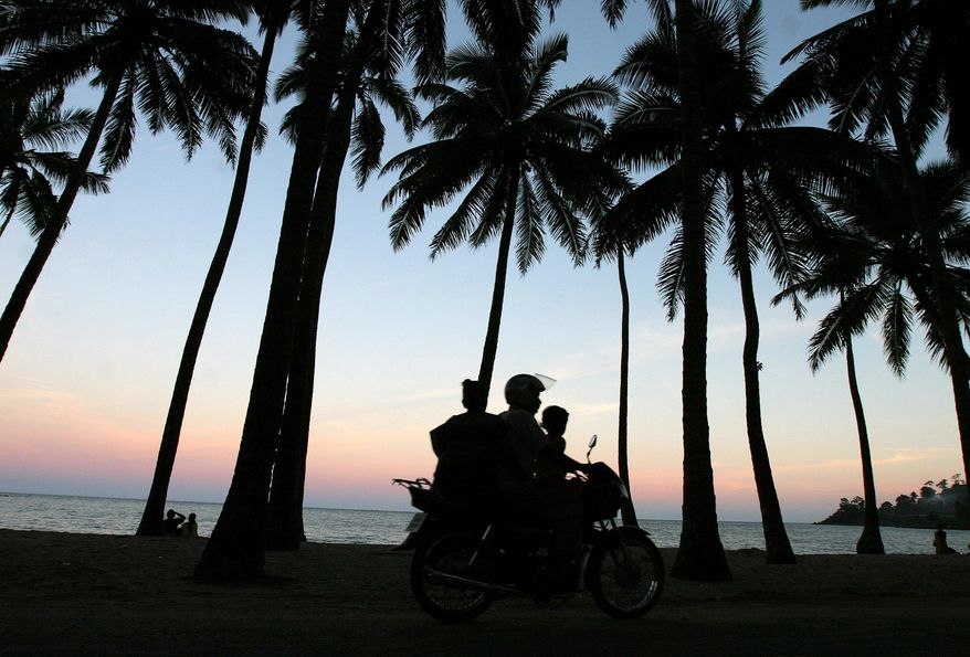 A motorist drives along the sea shore with his family in Port Blair, in India's Andaman and Nicobar Islands archipelago, Saturday, Sept. 8, 2007. Four members of a small tribe in the remote Andaman and Nicobar Islands have tested positive for the coronavirus. An Indian health official says the four are among the 37 members of the Great Andamanese tribe who live on Strait Island. (AP Photo/Aijaz Rahi, File)