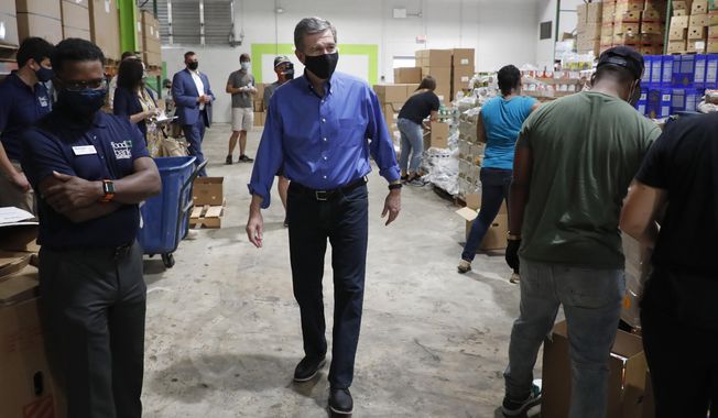 North Carolina Gov. Roy Cooper tours the Food Bank of Central &amp;amp; Eastern North Carolina food bank in Raleigh, N.C., Thursday, Aug. 27, 2020. (Ethan Hyman/The News &amp;amp; Observer via AP)