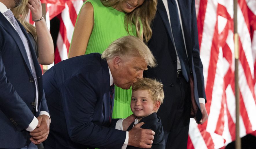 President Donald Trump kisses grandson Theodore James Kushner, with first lady Melania Trump, on the South Lawn of the White House on the fourth day of the Republican National Convention, Thursday, Aug. 27, 2020, in Washington. (AP Photo/Alex Brandon)