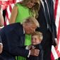 President Donald Trump kisses grandson Theodore James Kushner, with first lady Melania Trump, on the South Lawn of the White House on the fourth day of the Republican National Convention, Thursday, Aug. 27, 2020, in Washington. (AP Photo/Alex Brandon)
