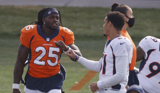 Denver Broncos running back Melvin Gordon, left, greets safety Justin Simmons as they take part in drills during an NFL football practice Friday, Aug. 28, 2020, in Englewood, Colo. (AP Photo/David Zalubowski)