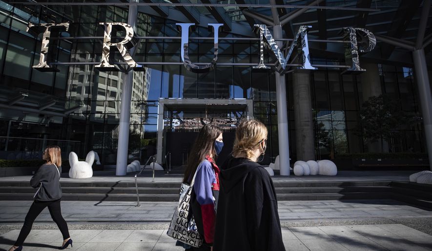People walk past the closed Trump International Hotel Vancouver, in Vancouver, British Columbia, Friday, Aug. 28, 2020. (Darryl Dyck/The Canadian Press via AP)
