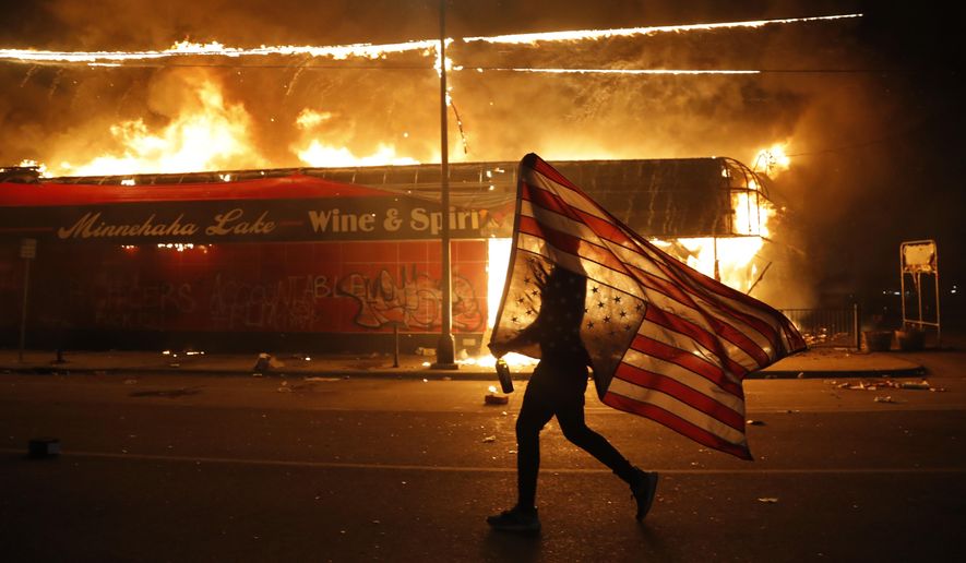 A protester carries a U.S. flag upside down, a sign of distress, next to a burning building, Thursday, May 28, 2020, in Minneapolis during protests over the death of George Floyd. Speaking at the Republican National Convention, President Donald Trump said, &amp;quot;The Republican Party condemns the rioting, looting, arson and violence we have seen in Democrat-run cities all, like Kenosha, Minneapolis, Portland, Chicago and New York, and many others.&amp;quot; (AP Photo/Julio Cortez, File)
