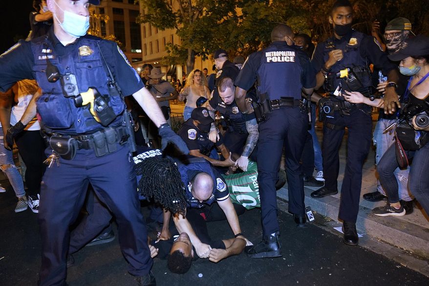 Metropolitan Police confront protesters on the ground along a section of 16th Street NW, renamed Black Lives Matter Plaza, Thursday night, Aug. 27, 2020, in Washington, after President Donald Trump had finished delivering his acceptance speech from the White House South Lawn. (AP Photo/Julio Cortez) **FILE**