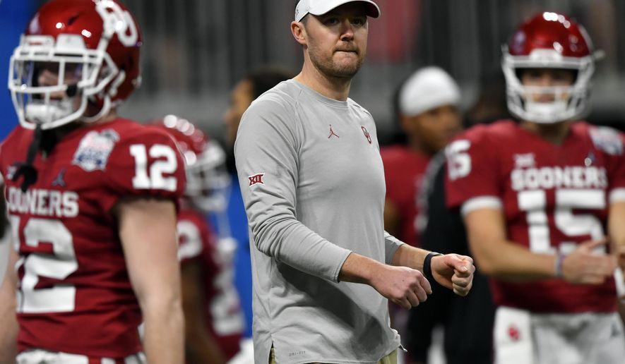 FILE - In this Dec. 28, 2019, file photo, Oklahoma head coach Lincoln Riley, center, stands with his team before the Peach Bowl NCAA semifinal college football playoff game against LSU in Atlanta. College football teams set to play this fall are trying to help their depth amid the coronavirus pandemic by finding players capable of playing multiple positions. Riley says it is “something every coach in the country is thinking about right now.” That's because positive tests, contact tracing and quarantines could abruptly alter any roster. (AP Photo/John Amis, File)