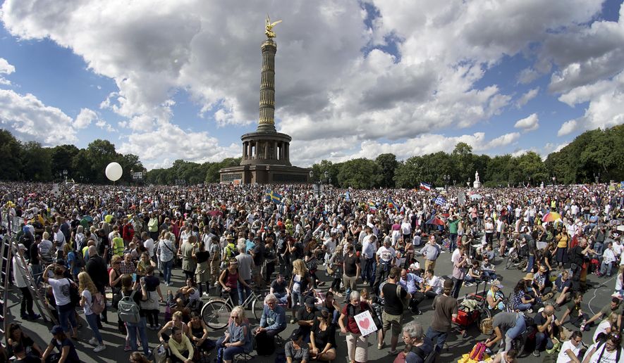 People gather at the Victory Column as they attend a protest rally in Berlin, Germany, Saturday, Aug. 29, 2020 against new coronavirus restrictions in Germany. Police in Berlin have requested thousands of reinforcements from other parts of Germany to cope with planned protests at the weekend by people opposed to coronavirus restrictions. (AP Photo/Michael Sohn)