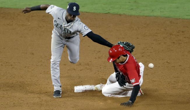 Seattle Mariners second baseman Shed Long Jr., left, misses the ball as Los Angeles Angels&#x27; Shohei Ohtani steals second base during the sixth inning of a baseball game in Anaheim, Calif., Friday, Aug. 28, 2020. (AP Photo/Alex Gallardo)