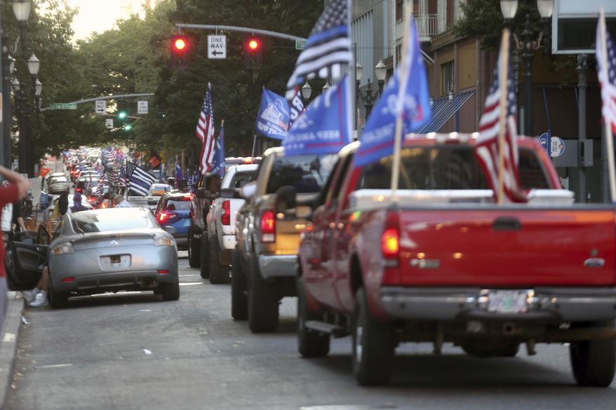 A caravan of supporters of President Donald Trump drive in downtown Portland, Ore., Saturday, Aug. 29, 2020. Saturday&#x27;s rally was the third consecutive weekend that pro-Trump demonstrators converged in and around Portland, leading to clashes with counter protesters. (Dave Killen/The Oregonian via AP)