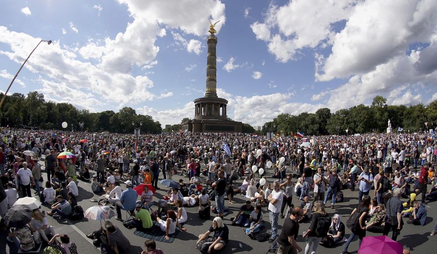 People gather at the Victory Column as they attend a protest rally in Berlin, Germany, Saturday, Aug. 29, 2020 against new coronavirus restrictions in Germany. Police in Berlin have requested thousands of reinforcements from other parts of Germany to cope with planned protests at the weekend by people opposed to coronavirus restrictions. (AP Photo/Michael Sohn)