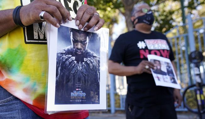 A portrait of the late actor Chadwick Boseman as the character T&#x27;Challa in the 2018 film &amp;quot;Black Panther&amp;quot; is held by a participant in a news conference celebrating his life, Saturday, Aug. 29. 2020, in Los Angeles. Boseman died Friday at 43 after a four-year fight with colon cancer. (AP Photo/Chris Pizzello)