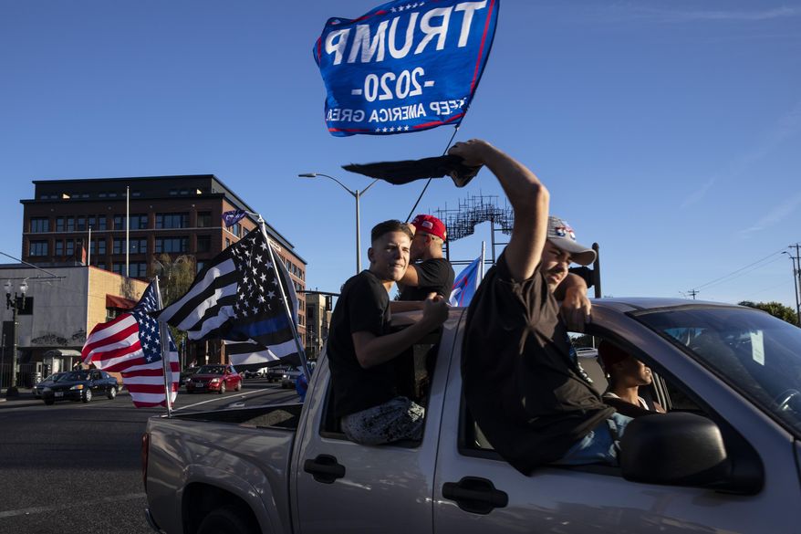 Supporters of President Donald Trump attend a rally and car parade Saturday, Aug. 29, 2020, in Clackamas, Ore., on the way to Portland. (AP Photo/Paula Bronstein )