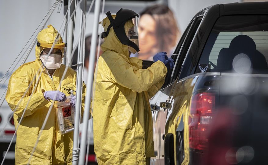 Medical personnel conduct drive-thru COVID-19 testing Monday afternoon May 4, 2020, at Rehoboth McKinley Christian Health Care Services in Gallup, N.M. New Mexico Gov. Michelle Lujan Grisham used her veto power to preserve executive control over hundreds of millions of dollars in federal coronavirus relief funding in the budget solvency bill she recently signed. The move could mean less financial assistance for some Native American communities. (Roberto E. Rosales/The Albuquerque Journal via AP)