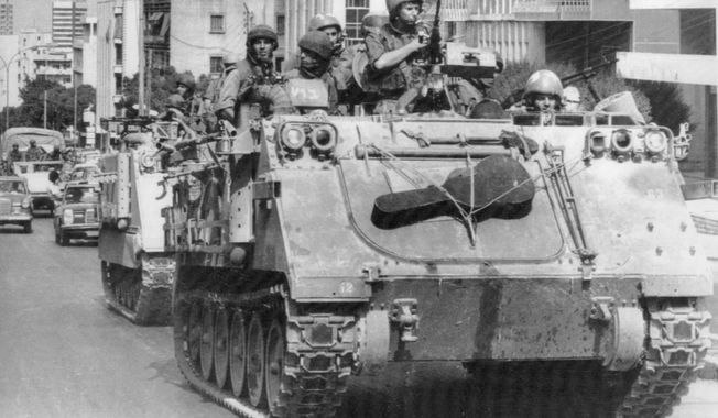 In this Sept. 28, 1982 file photo, Israeli tanks rumble through West Beirut streets, having just left the West Beirut port area. It was a century ago on Sept. 1, 1920, that a French general, Henri Gouraud, stood on the porch of the French residence in Beirut surrounded by local politicians and religious leaders and declared the State of Greater Lebanon - the precursor to the modern state of Lebanon. (AP Photo/Saris, File)