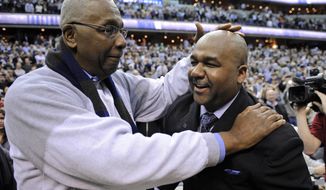 FILE - In this March 9, 2013, file photo, former Georgetown coach John Thompson Jr., left, congratulates his son Georgetown head coach John Thompson III, right, after the Hoya&#39;s 61-39 win over Syracuse in an NCAA college basketball game in Washington. John Thompson, the imposing Hall of Famer who turned Georgetown into a “Hoya Paranoia” powerhouse and became the first Black coach to lead a team to the NCAA men’s basketball championship, has died. He was 78 His death was announced in a family statement Monday., Aug. 31, 2020. No details were disclosed. (AP Photo/Nick Wass, File)
