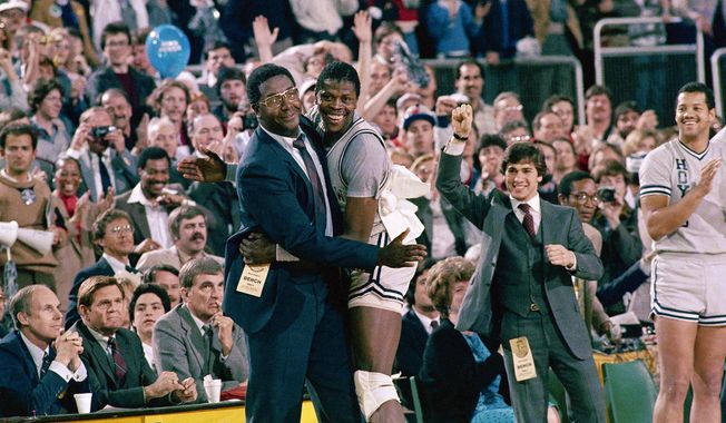 FILE - In this April 2, 1984, file photo, Georgetown head coach John Thompson, left, gives a happy pat to the most valuable player Patrick Ewing, after Georgetown defeated Houston 84-75 in Seattle. John Thompson, the imposing Hall of Famer who turned Georgetown into a “Hoya Paranoia” powerhouse and became the first Black coach to lead a team to the NCAA men’s basketball championship, has died. He was 78 His death was announced in a family statement Monday., Aug. 31, 2020. No details were disclosed.(AP Photo/File)