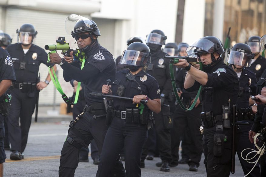 FILE - Police aim weapons on demonstrators protesting the death of George Floyd in Los Angeles, Saturday, May 30, 2020. Supporters of legislation allowing for "bad officers" to be permanently stripped of their badges were twisting arms and calling out opponents on Monday, Aug. 31, 2020, as they struggled for votes on one of the year's top policing reform bills. (AP Photo/Ringo H.W. Chiu, File)
